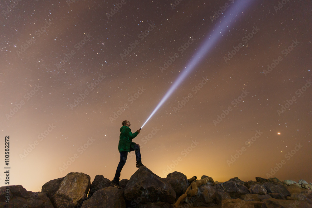 Silhouette of man with flashlight, wide stars and visible Milky way galaxy - obrazy, fototapety, plakaty 