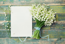 Bouquet Of Flowers Lily Of The Valley And Empty Paper Sheet On Rustic Table From Above, Beautiful Vintage Card, Top View, Copy Space For Text, Flat Lay