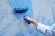 workman painting the wall in blue