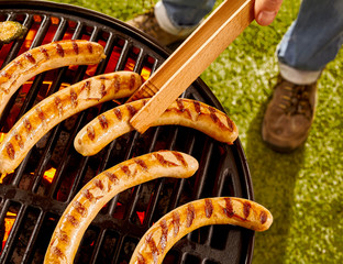 Wall Mural - Man Grilling Sausages on Hot Barbecue Grill