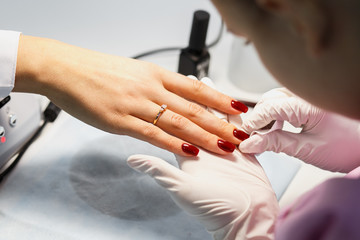 Manicure care procedure, Close-up photo Of Beautician Hand Painting Nails Of Woman In Salon