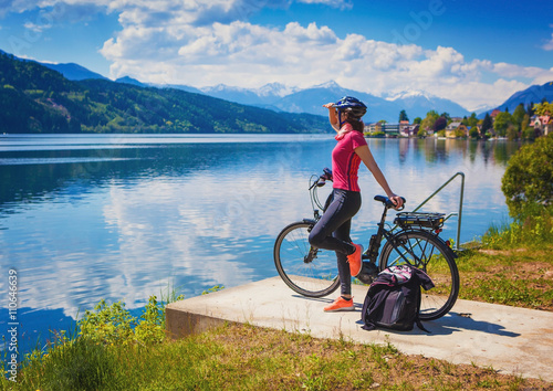 Cuadros en Lienzo Mujer con la e-bici disfrutando de la vista sobre el lago