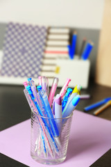 Wall Mural - Set of colored pens in glass on black table, close up