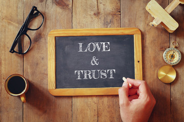 Wall Mural - man writes on a blackboard a phrase: LOVE&TRUST