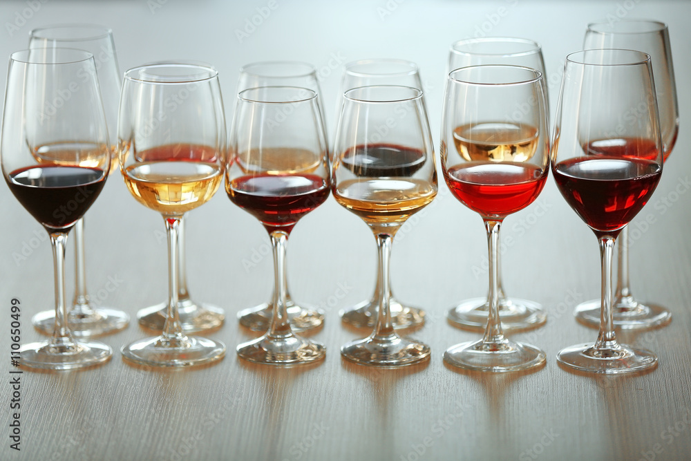 Many glasses of different wine in a row on a table