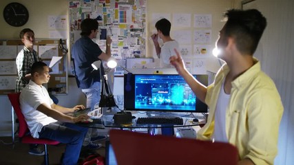  Group of young male computer programmers working together in small office