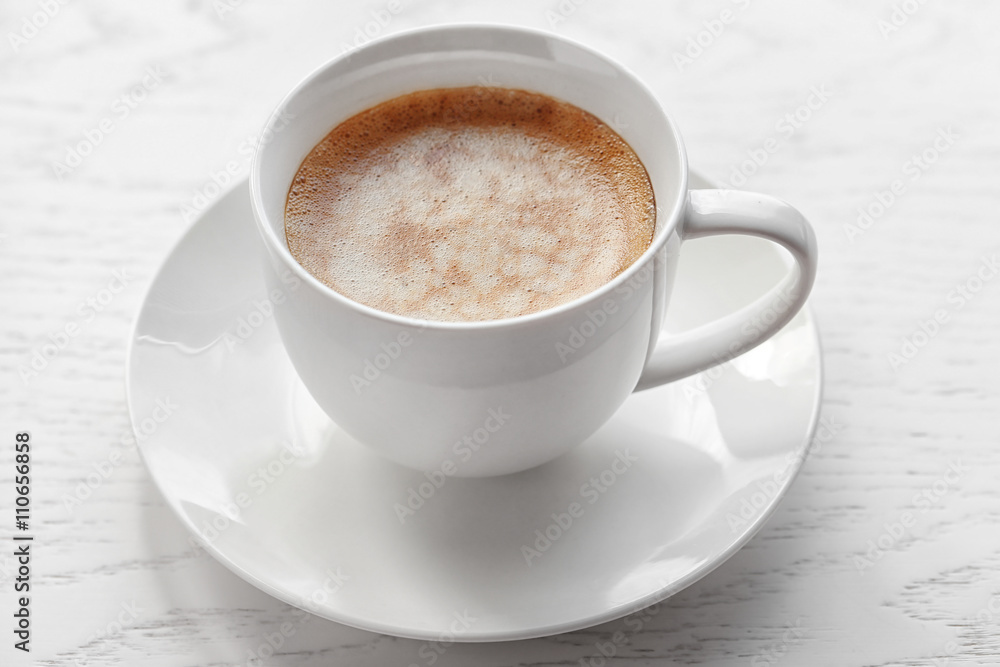 Cup of coffee on light wooden background
