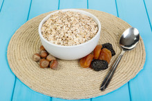 In A White Bowl, Oatmeal, Nuts And Dried Fruits On Background  Wooden Planks Painted In Blue Color.