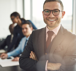 Canvas Print - Smiling confident businessman with folded arms