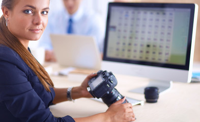 Female photographer sitting on the desk with laptop