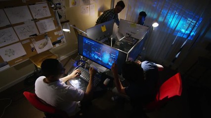  Young creative computer design team working together in dark office.