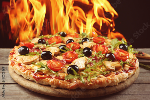 Delicious Hot Pizza On Wooden Table Against Fire Flame Background Buy This Stock Photo And Explore Similar Images At Adobe Stock Adobe Stock