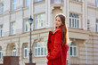 © timonko - young beautiful woman in red coat in the city