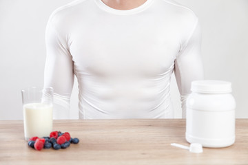 Wall Mural - Closeup on a man with nutiotion supplements on table