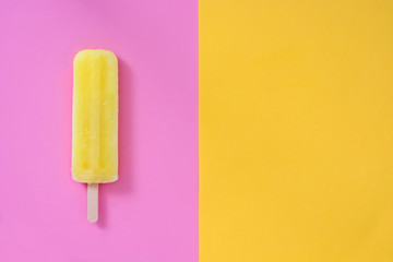 Lemon popsicle on pink and yellow background
