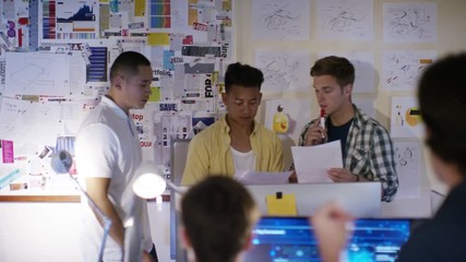  Group of young male computer programmers working together in small office