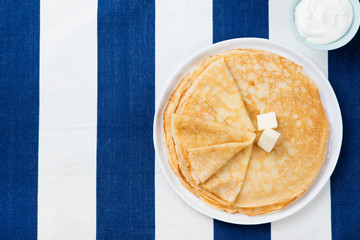 Wall Mural - Thin crepes or pancakes with butter, honey and sour cream Top view Copy space