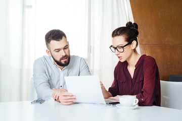 Two serious young businesspeople working together on business meeting