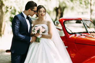 Wall Mural - Groom in the sunglasses cuddles his gorgeous bride