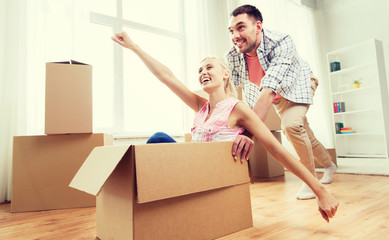 Poster - couple with cardboard boxes having fun at new home