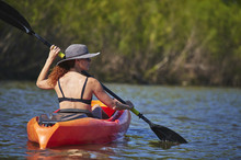 A Young Woman Paddling A Kayak