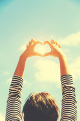 Poster - Young girl holding hands on blue sky background. Retro style