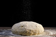 dough is sprinkled with flour on black  background
