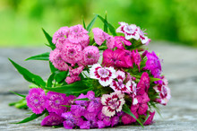 Bouquet Of Small Carnations On A Wooden Background