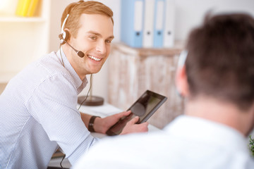 Wall Mural - Pleasant smiling man talking with his colleague 