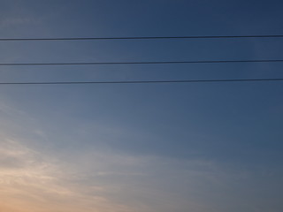 Triple power cables and sunset, blue sky