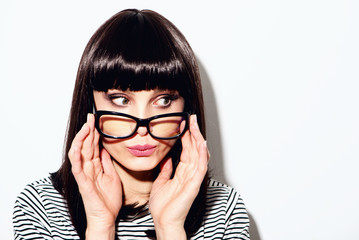 Fashion studio portrait of pretty young hipster brunette woman with bright sexy make up and glasses