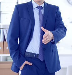 Wall Mural - Business and office concept - handsome businessman with open hand ready for handshake