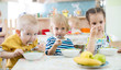 © Andrey Kuzmin - children eating from plates in day care centre