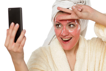 young beautiful woman taking selfies with a mask on her face