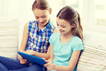 Wall Mural - happy girls with tablet pc sitting on sofa at home