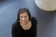 © Connect Images - High angle view of woman wearing telephone headset looking at camera smiling