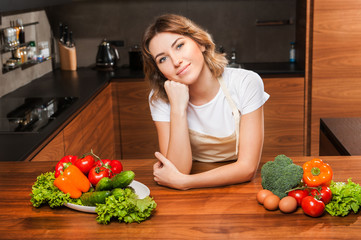 Young and beautiful housewife woman cooking in a kitchen