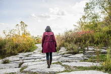 Mid Adult Woman Walking On Rocks, Rear View