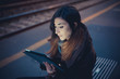 © Connect Images - Mid adult woman using digital tablet on railway platform at dusk