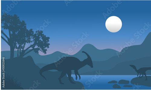 Cuadros en Lienzo eoraptor and parasaurolophus in river scenery silhouette