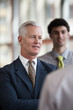 © .shock - portrait of senior businessman as leader  with staff in backgrou