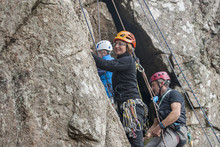 Three Rock Climbers On Cliff