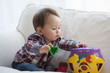 © Connect Images - Baby boy playing with shape sorter toy