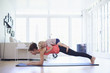 © Connect Images - Mid adult mother practicing yoga with toddler daughter on top of her