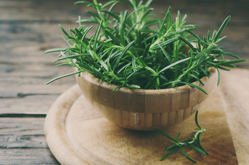 Wall Mural - Fresh green aromatic rosemary on the wooden table