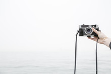 Person Taking Selfie With Camera, Sea In Background