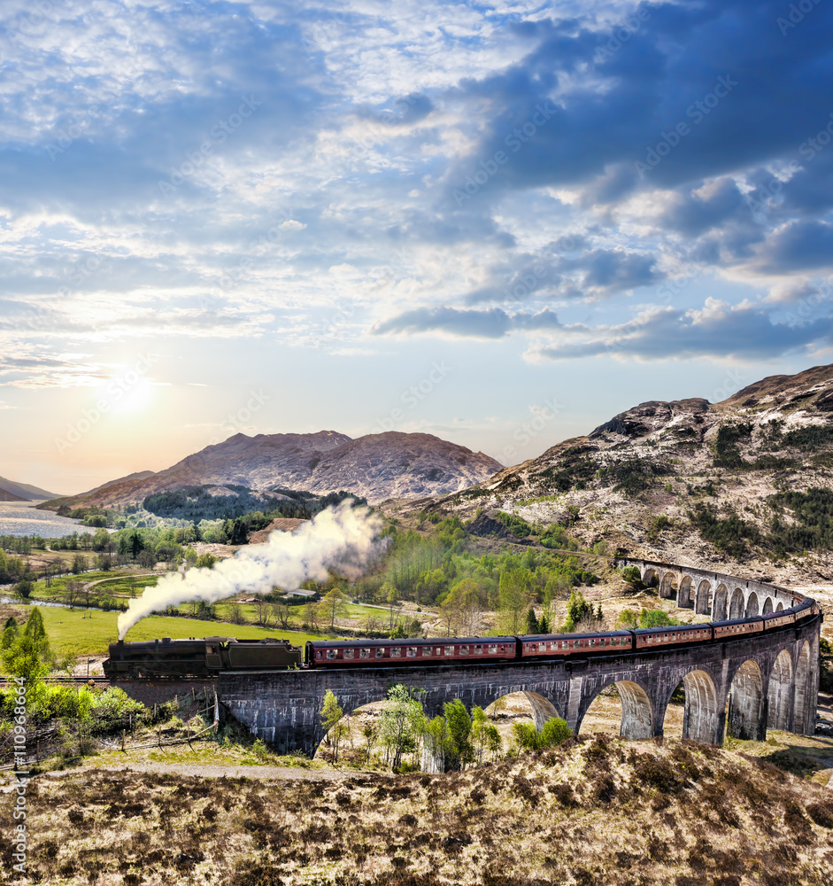 Glenfinnan Railway Viaduct in Scotland with the Jacobite steam train against sunset over lake - obrazy, fototapety, plakaty 