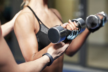 Woman With Dumbbells Flexing Muscles In Gym