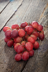 Wall Mural - Bunch of red grapes, on wooden surface.