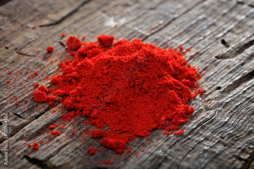 Cuadros en Lienzo A heap of paprika powder, on wooden surface.